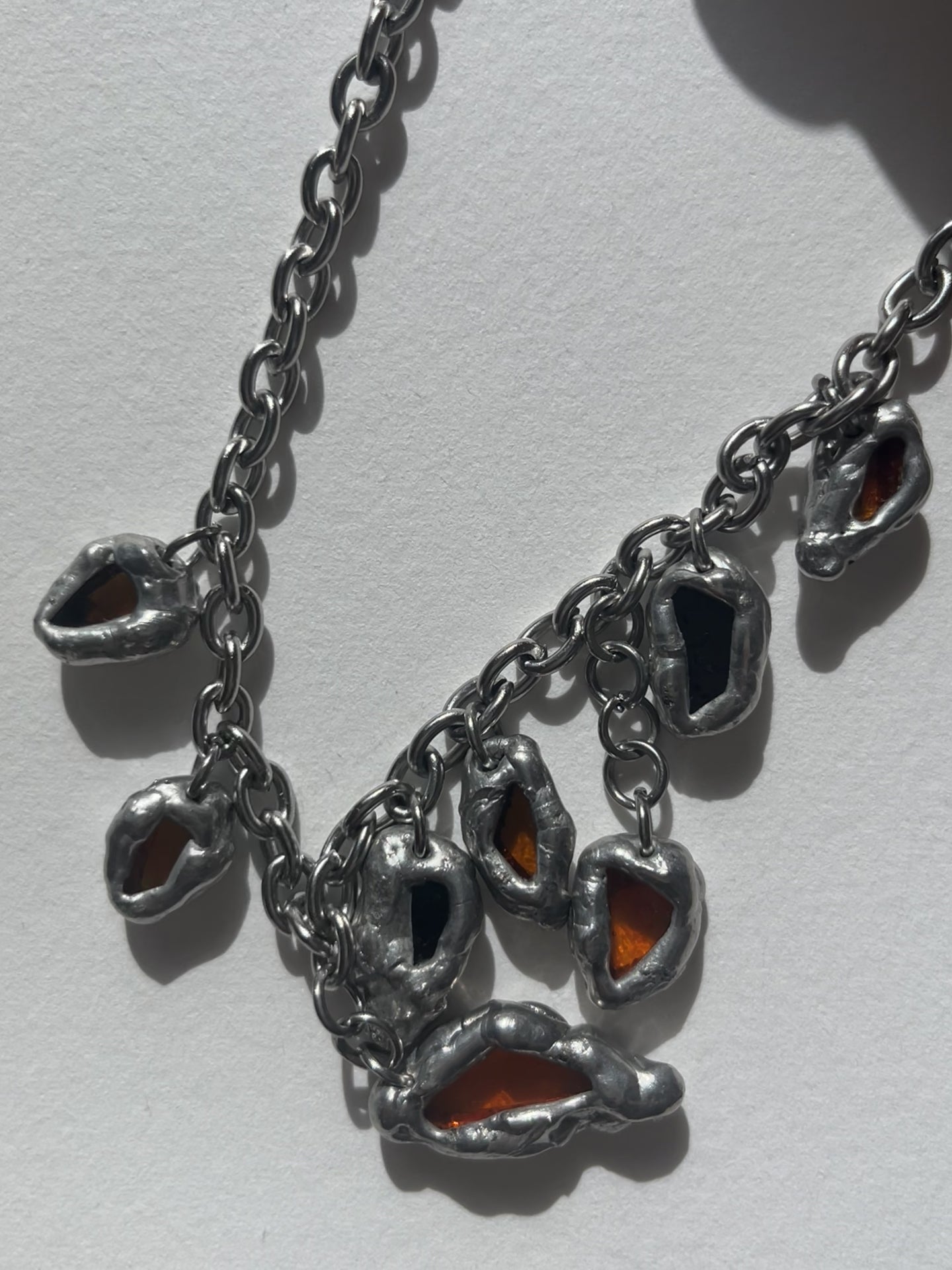 Textura y acabado artesanal de los colgantes del Collar DRIP ambar
